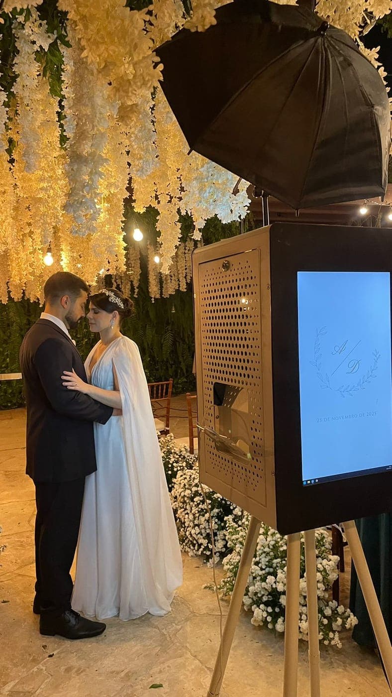 Casal de noivos ao lado do totem da Peek Print em casamento